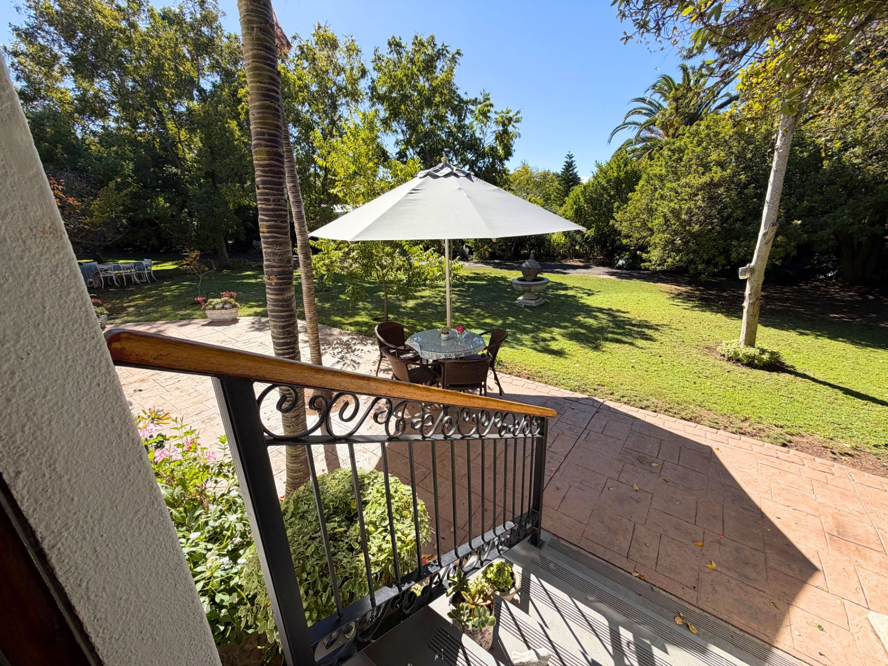 Patio and garden seating beneath a sun umbrella